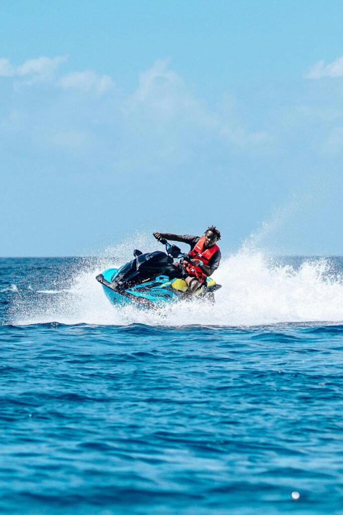 Man enjoying an exhilarating jet ski ride on the open sea under a clear blue sky.